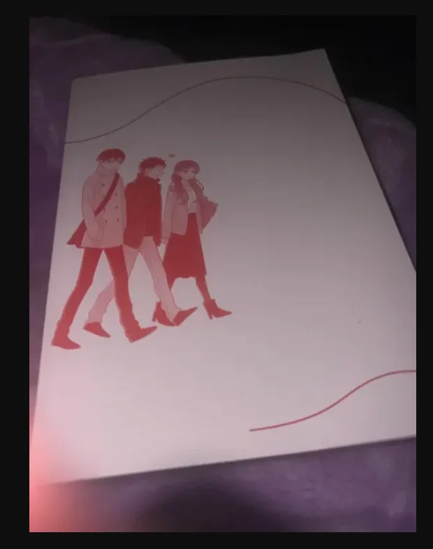 A printed anime-style illustration shows three characters walking together, two men and one woman, with a red heart above…