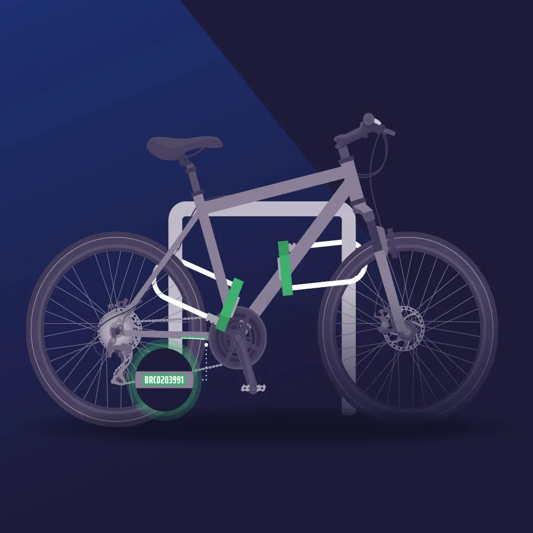 A stylized gray bicycle is shown locked to a white bike rack with green locking mechanisms at the frame and rear wheel. A…