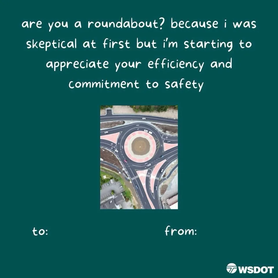 An aerial photo of a large, multi-lane roundabout with cars circulating around its center. White text overlaid on a dark…