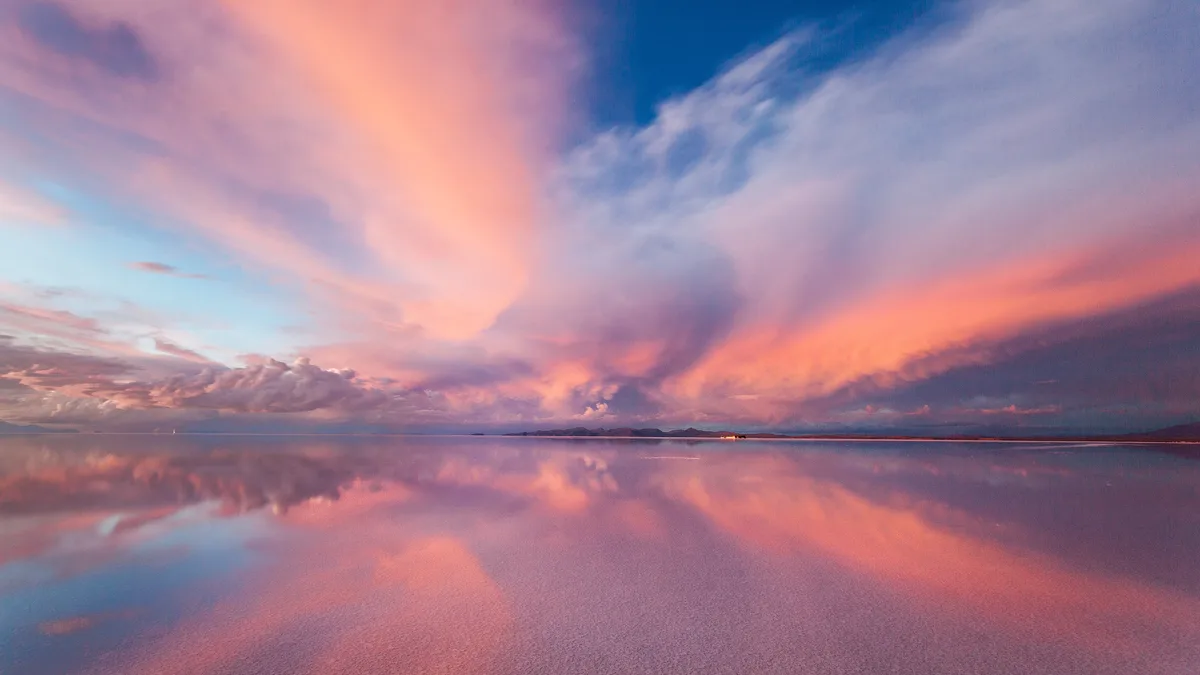 On Bolivia's Salar de Uyuni, a rare rain transforms the world's largest salt pan into a 4,000-square-mile mirror. A couple…