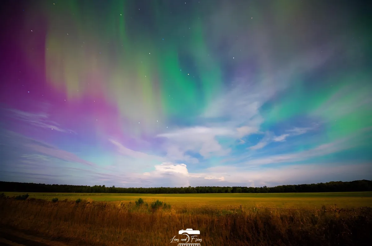A stunning photograph of a vibrant aurora borealis, displaying green, purple, and blue ribbons across a starry night sky…