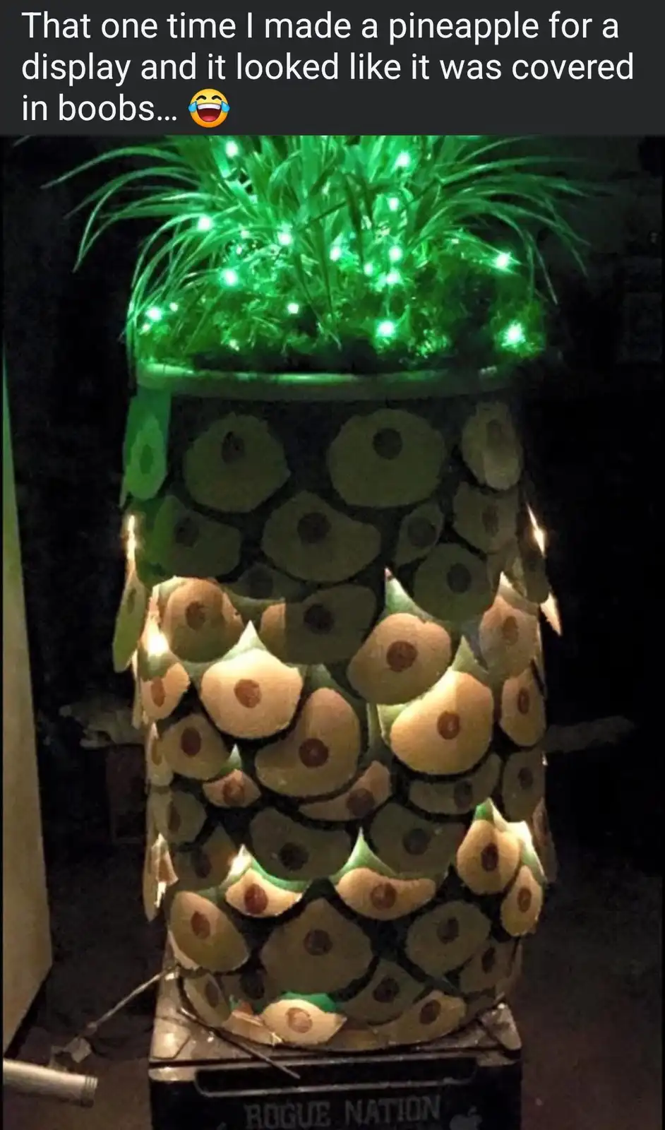 A large, illuminated pineapple-shaped display made from stacked pineapple slices, with green lights embedded in its crown…