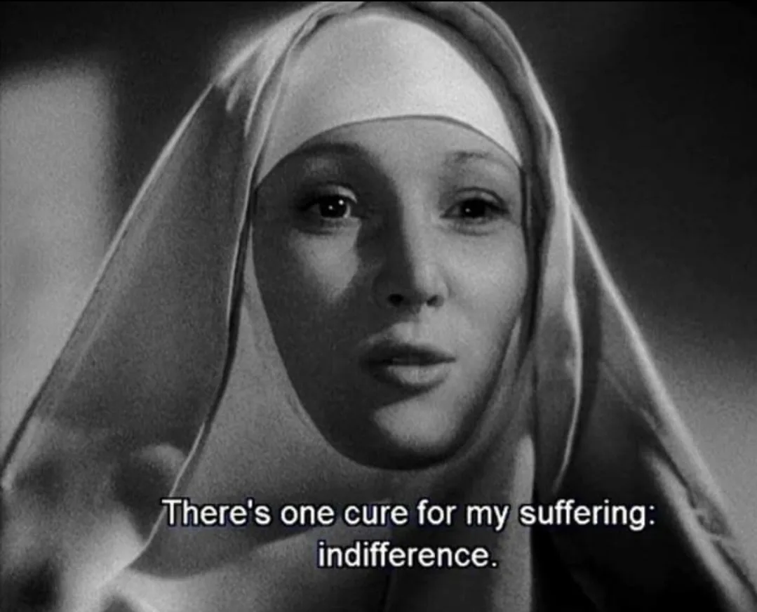 A black-and-white close-up of a woman in a nun's habit, looking directly at the camera with a somber expression. White text…