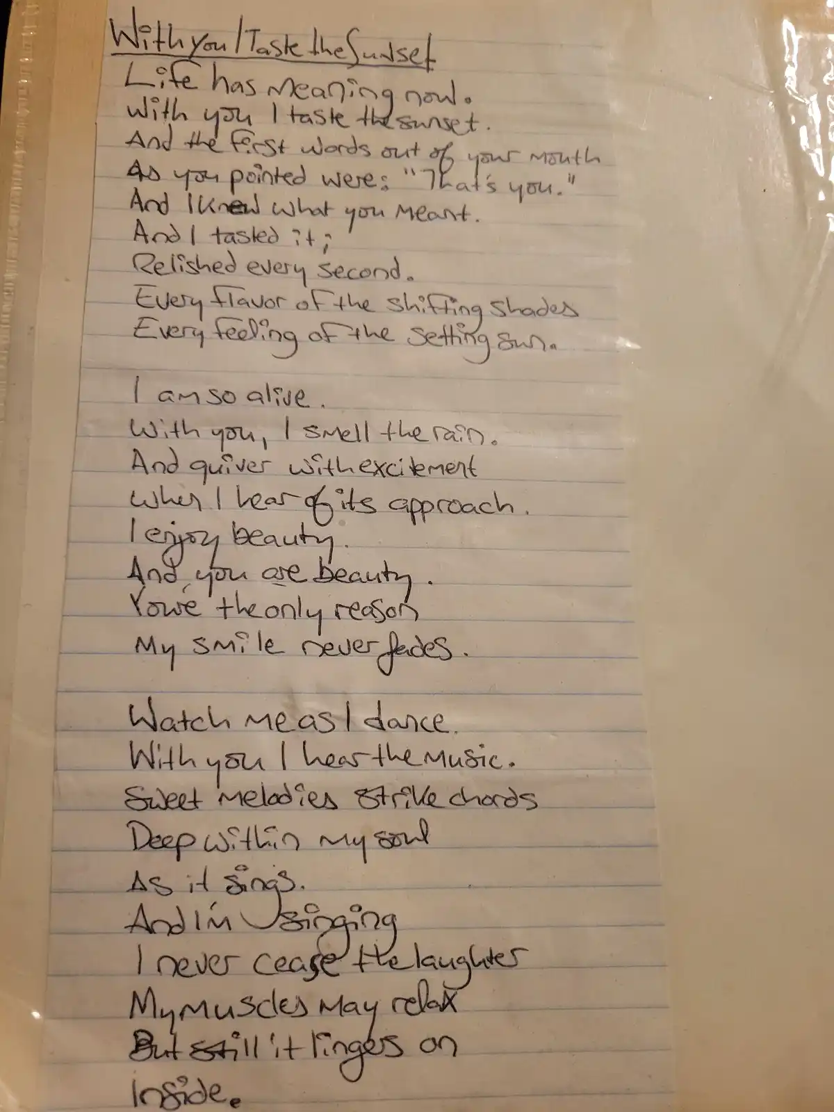 A handwritten poem on lined notebook paper, titled 'With you | Taste the Sunset,' describes romantic experiences like…