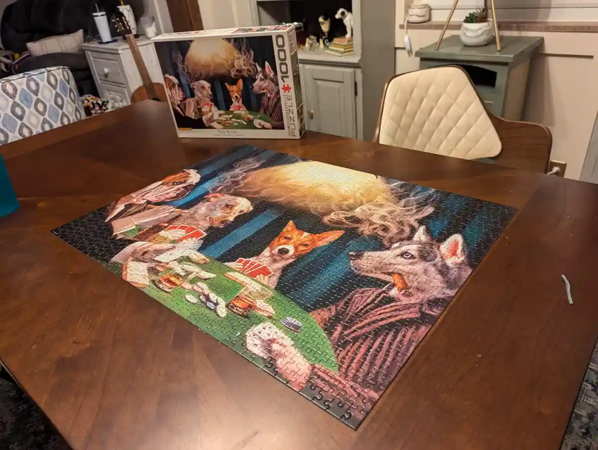 A completed 1000-piece jigsaw puzzle depicting anthropomorphic dogs playing poker around a green felt table, with one dog…