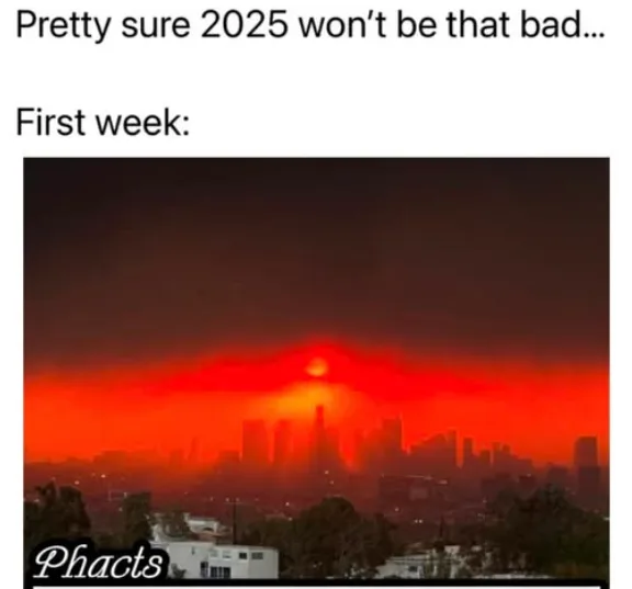 The image shows a city skyline under a sky filled with intense red-orange haze, with a glowing red sun visible through the…