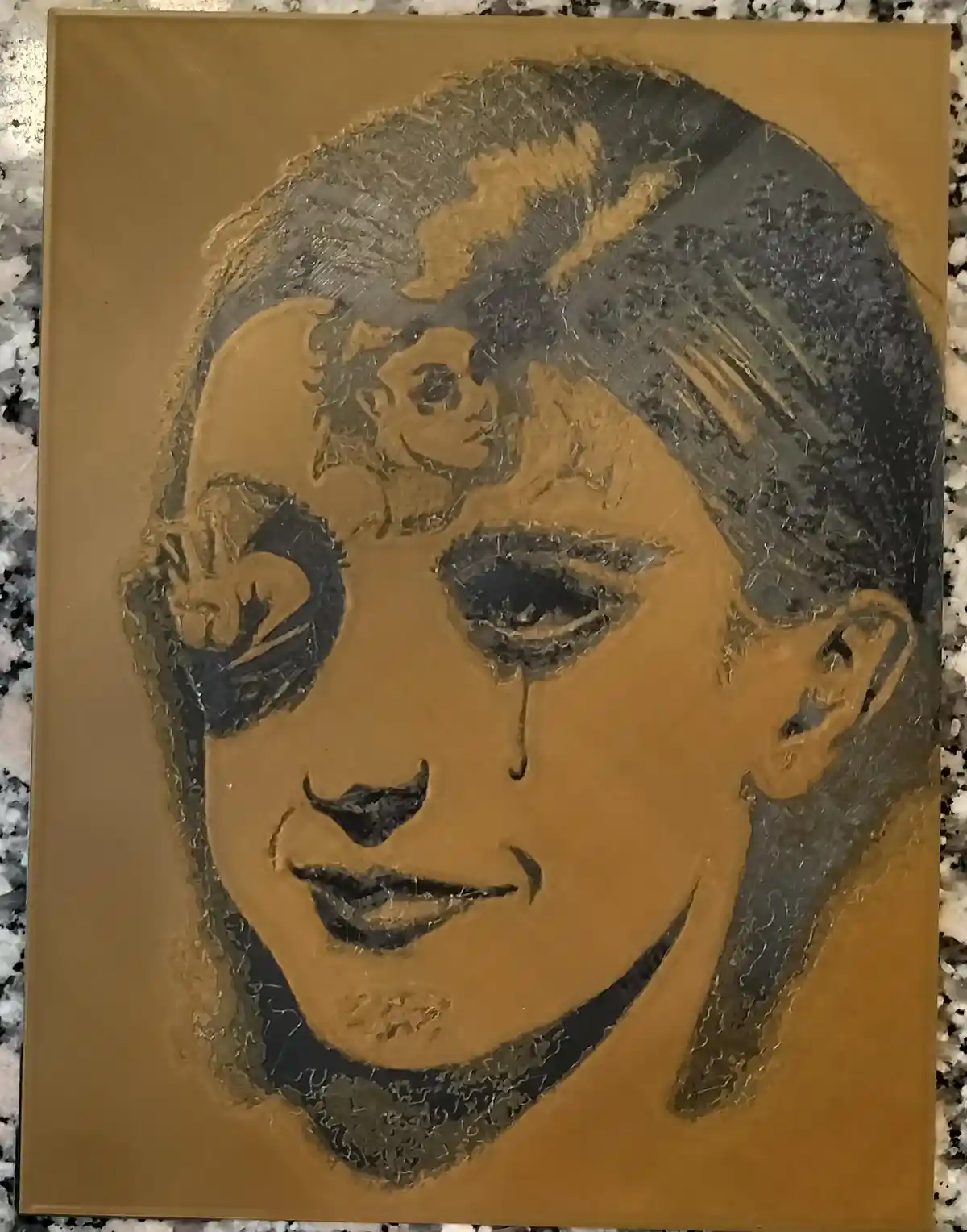 A textured, gold-toned portrait of a woman with a tear falling from her eye, yet she has a wide, smiling expression. The…