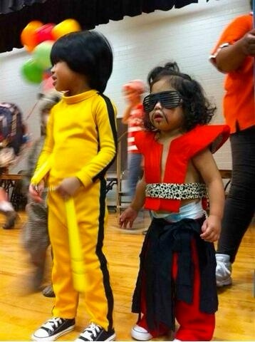 Two young children dressed as Michael Jackson stand side by side at what appears to be a party or school event. The child on…