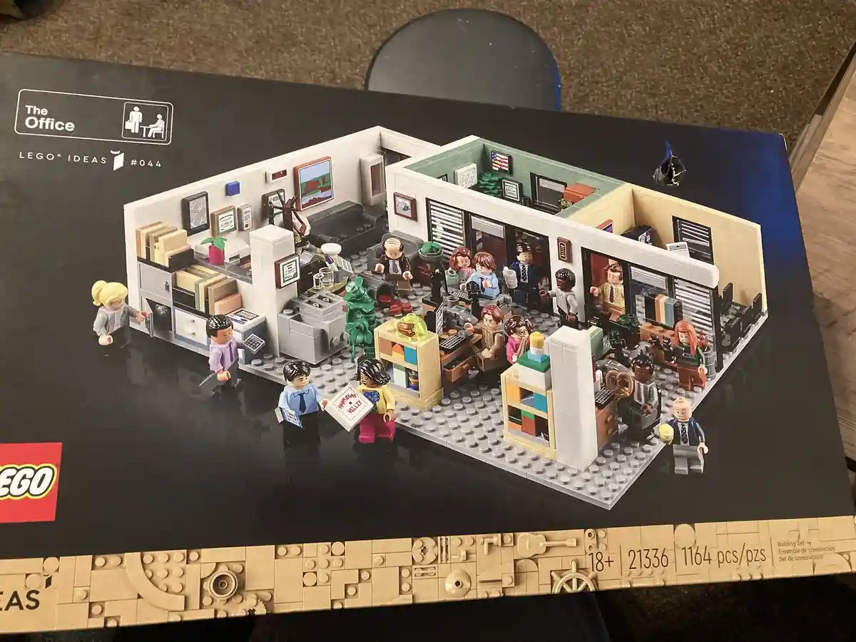 The image shows the box for the LEGO Ideas 'The Office' set #044, featuring a detailed LEGO recreation of the Dunder Mifflin…