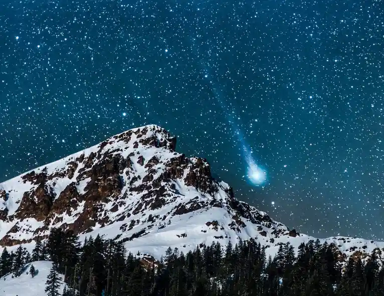 A starry night sky over a snow-covered mountain peak with a bright comet streaking across the upper right. The overlaid text…