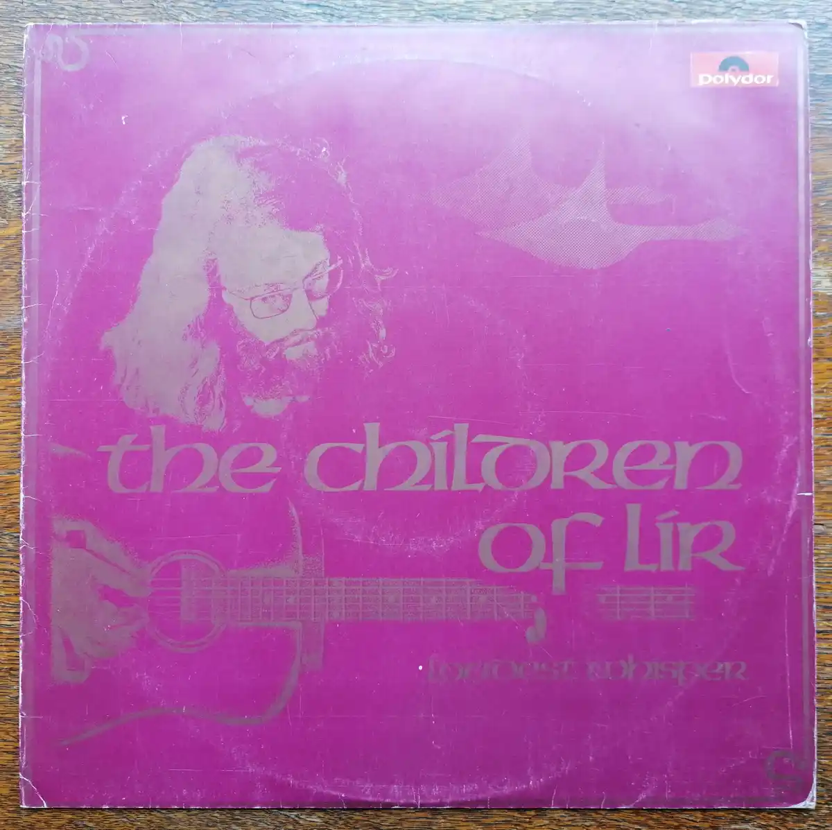 A vintage purple vinyl record sleeve for 'The Children of Lir' by 'Loudest Whisper', featuring a faded grey silhouette of a…