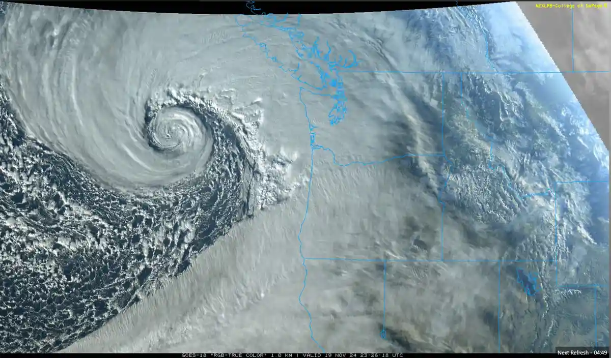 A satellite image shows a large, swirling storm system over the Pacific Ocean, with the western coast of North America…