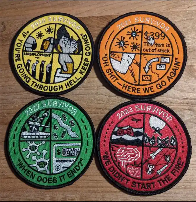 Four circular embroidered patches laid out on a wooden surface, each representing a year from 2020 to 2023. The 2020 patch…