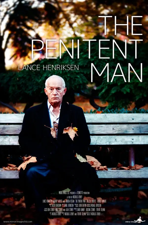 A movie poster for 'The Penitent Man' starring Lance Henriksen, showing him sitting solemnly on a park bench surrounded by…
