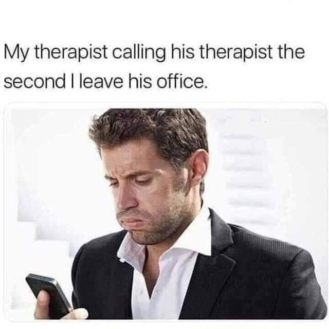 A man in a black suit and white shirt looks down at his phone with a confused, slightly disgusted expression. The overlaid…