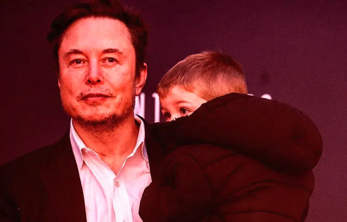 A man with dark hair and a light beard, wearing a white collared shirt and dark jacket, holds a young boy in a dark puffy…