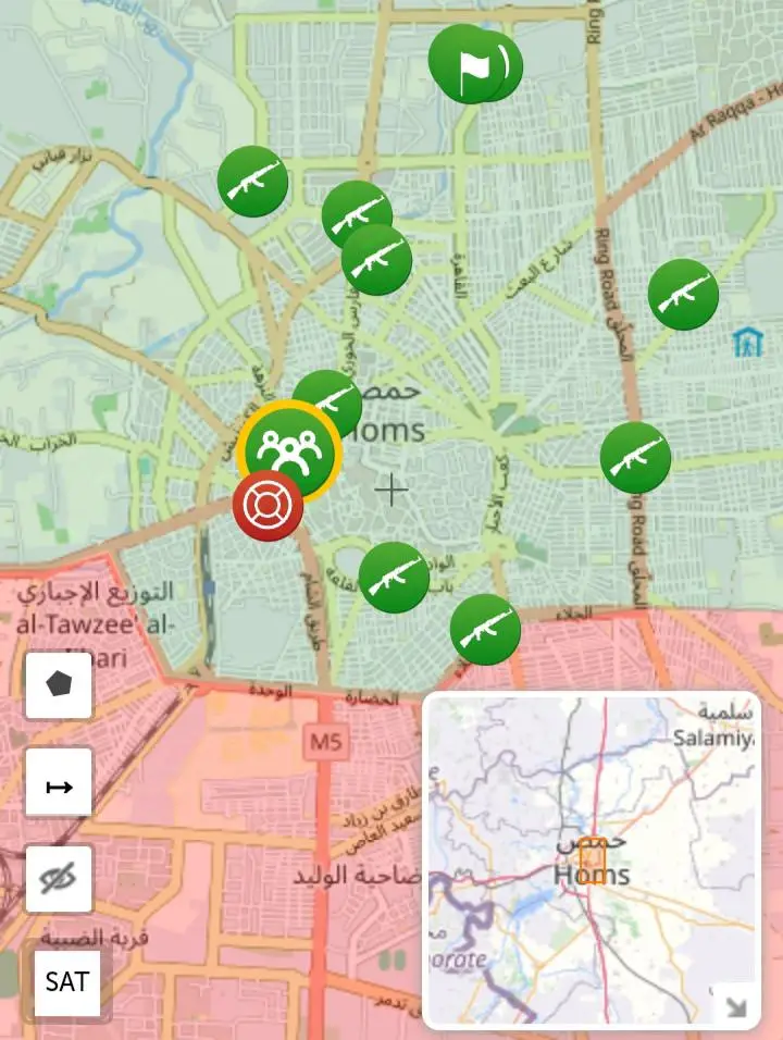 A map of Homs, Syria, shows numerous green icons with rifles and one red icon with a lifebuoy, overlaid with the text…