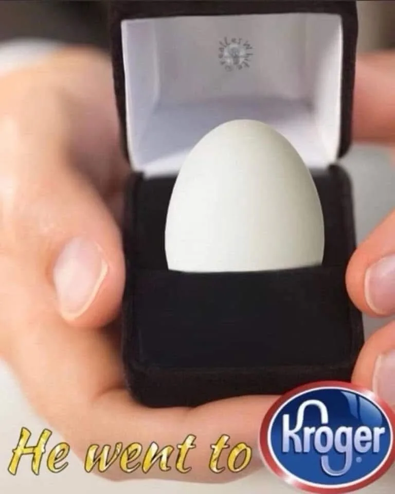 A close-up image shows two hands holding an open black velvet jewelry box, inside which rests a plain white egg. The box's…