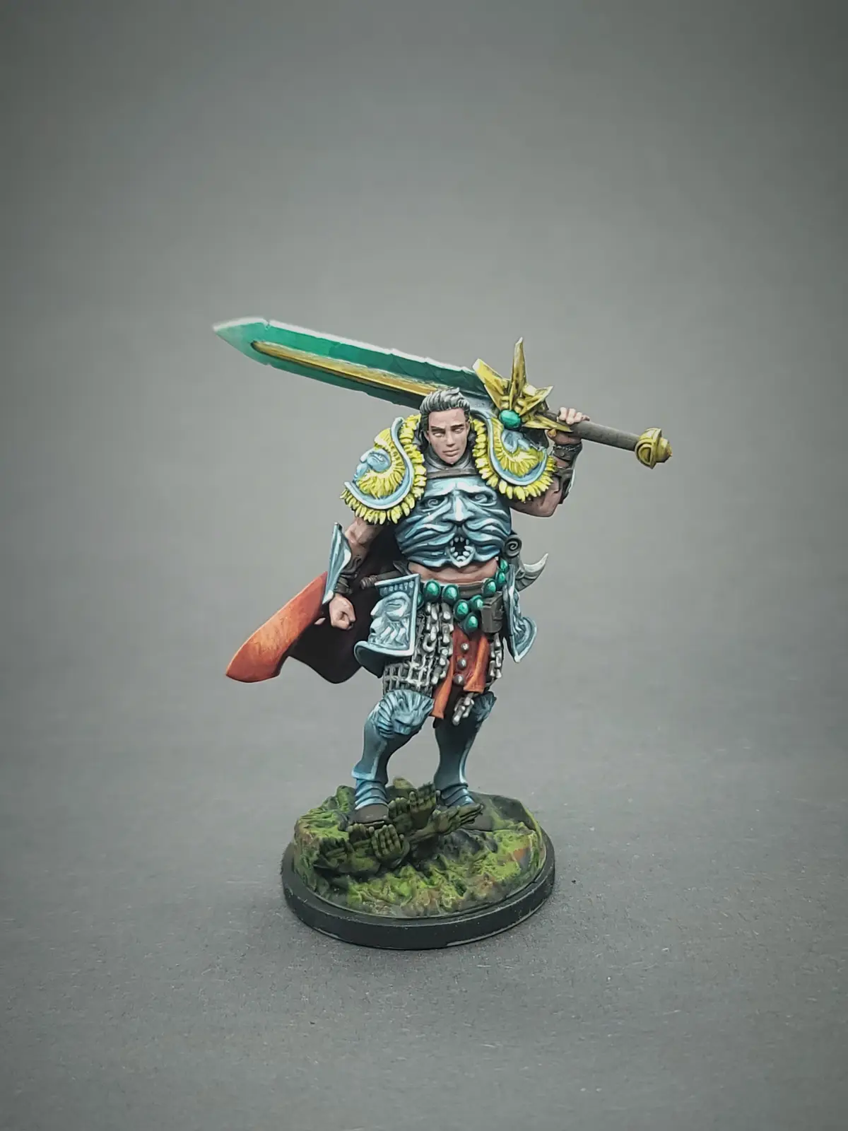 A highly detailed, painted miniature of a fantasy warrior stands on a circular base with mossy terrain, holding a large…