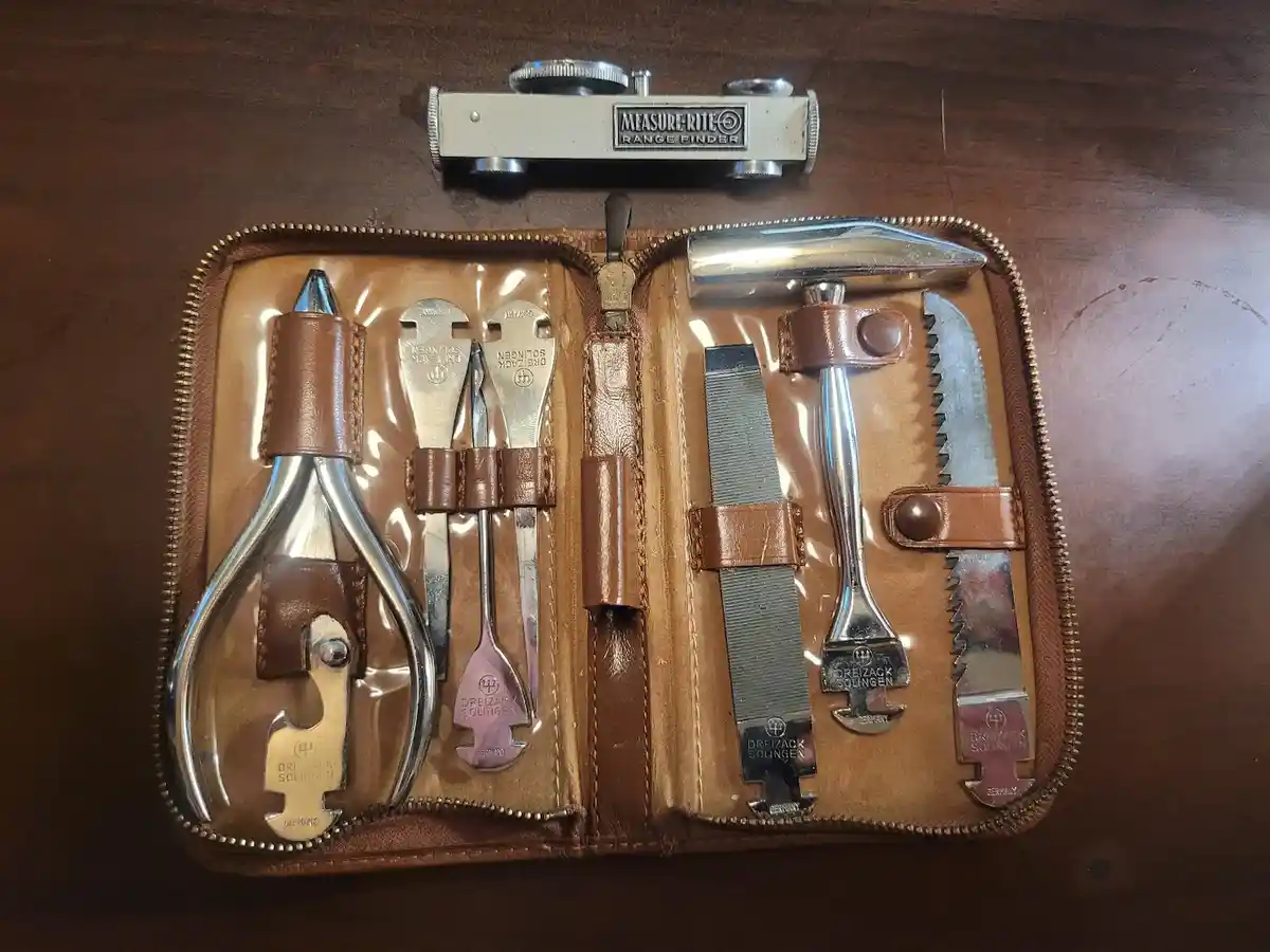 A vintage leather tool kit containing various metal tools like pliers, saws, and a hammer, neatly arranged in a zippered…