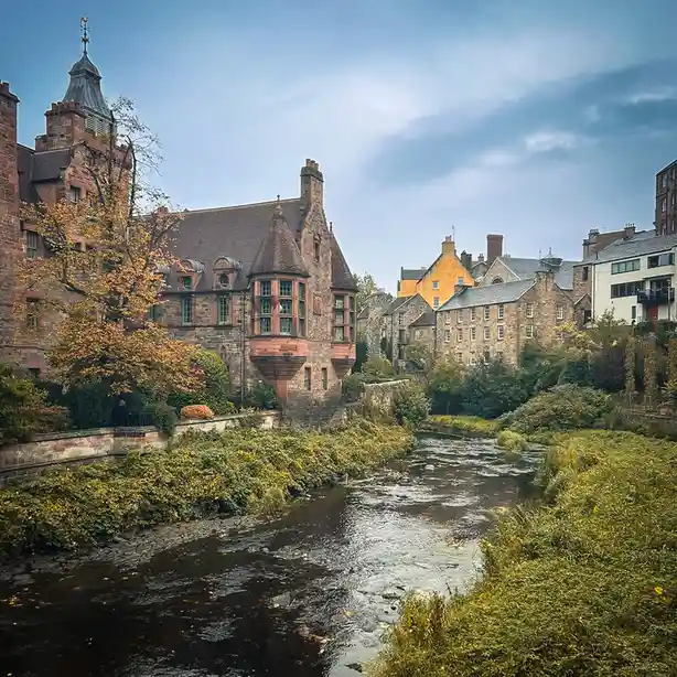 A scenic photo of a river flowing through a town with historic stone buildings and autumn foliage. Overlaid text reads 'i'm…