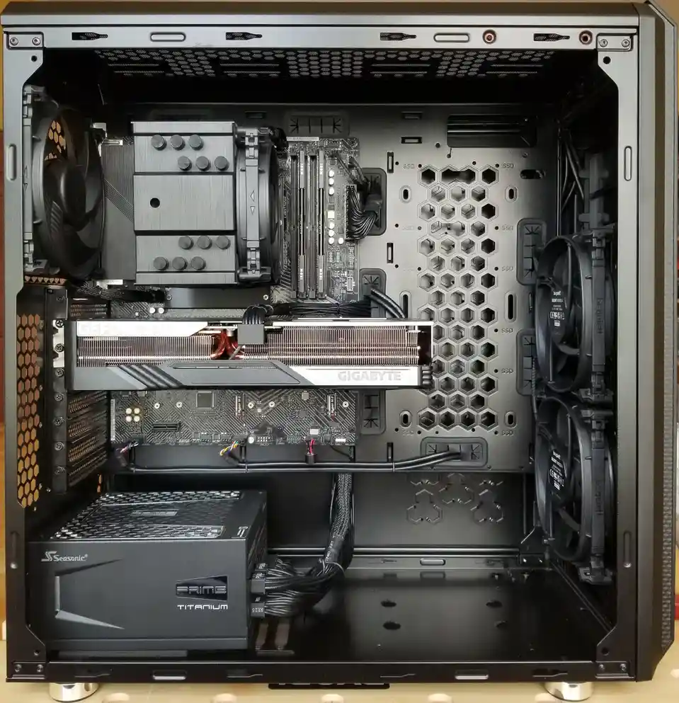 An overhead view of a high-end custom-built PC case with a large graphics card, CPU cooler, motherboard, and multiple fans…