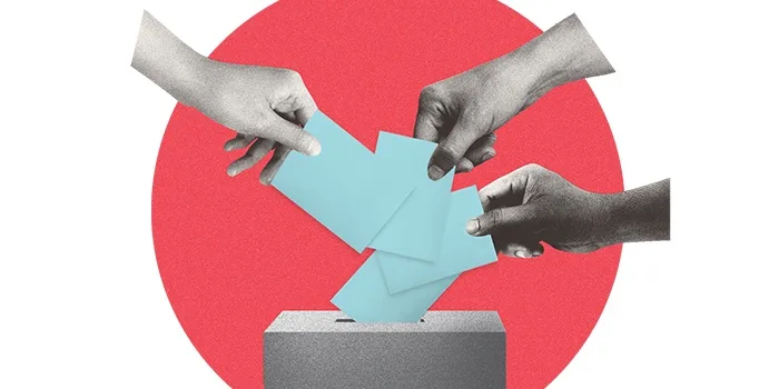 Three hands are shown dropping light blue paper ballots into a gray ballot box, set against a textured red circular…