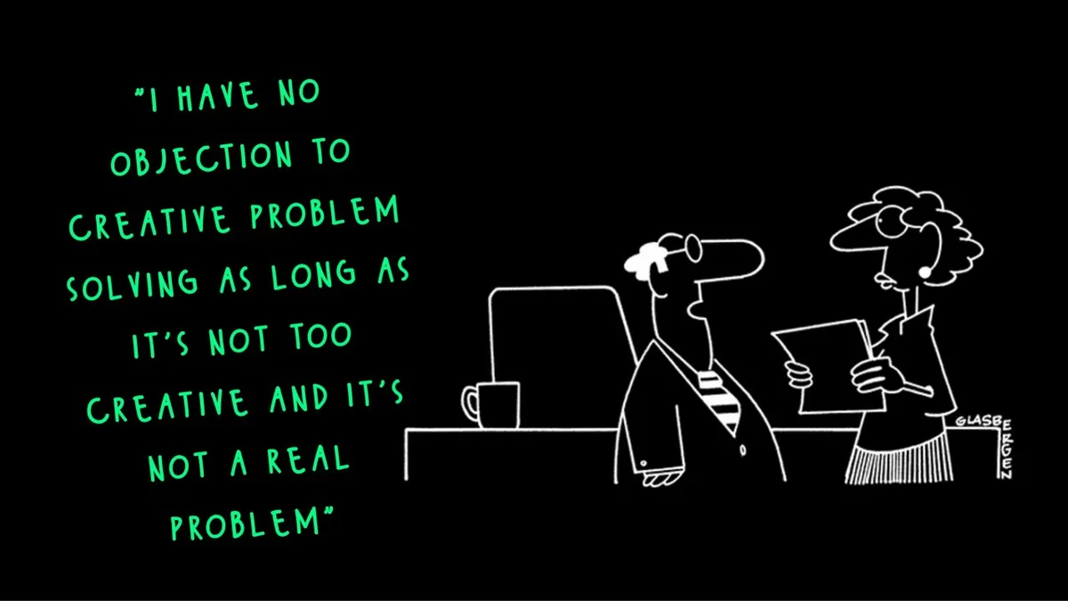 A black-and-white cartoon depicts two office workers at a desk; one is seated at a computer with a mug, while the other…