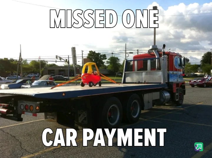 A red and yellow toy car is sitting on the flatbed of a large red and white tow truck in a parking lot. The text 'MISSED…