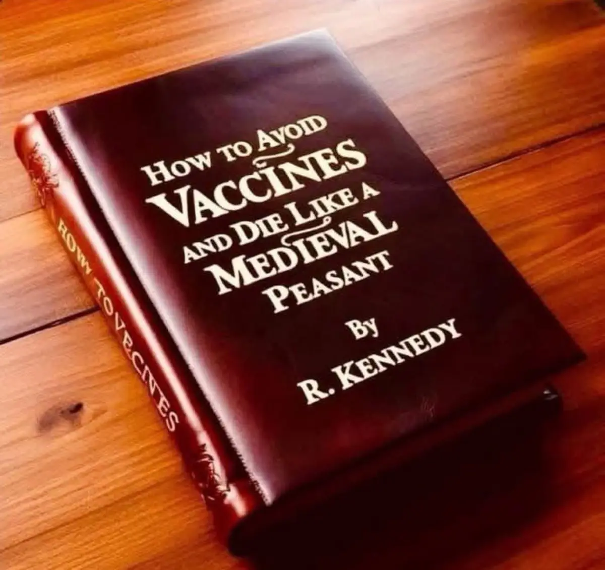 A dark brown leather-bound book with gold lettering lies on a wooden floor. The cover reads 'How to Avoid Vaccines and Die…