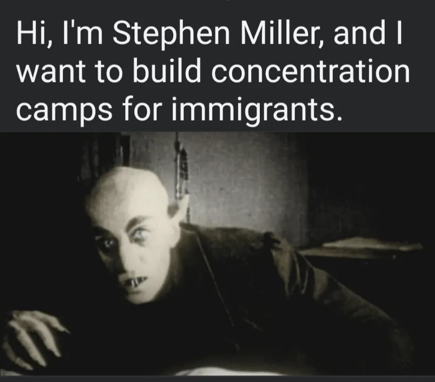 A black-and-white image shows a bald, pale man with wide, intense eyes and sharp teeth, looking menacingly forward. The text…
