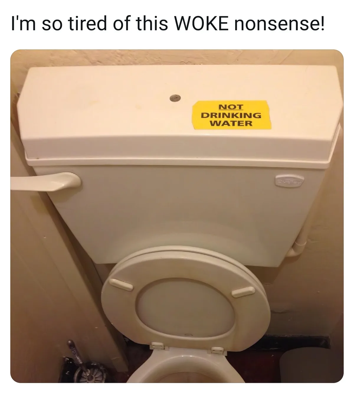 A close-up photo of a white toilet with the lid up, showing the tank and bowl. A yellow sticky note is taped to the top of…
