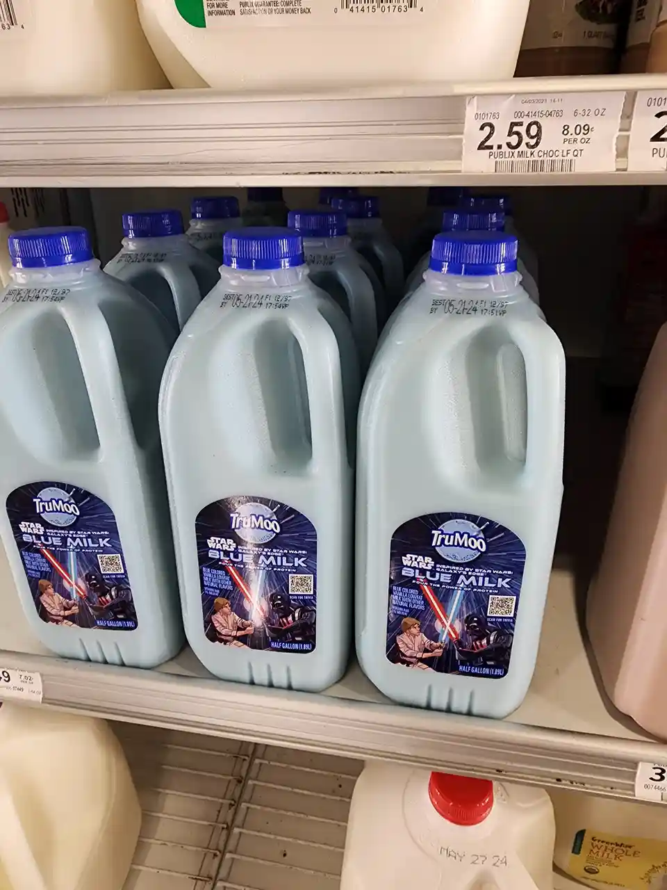 Several half-gallon plastic jugs of TruMoo 'Star Wars: Galaxy's Edge' Blue Milk, colored light blue and featuring a label…