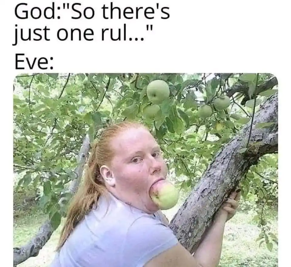 A woman with red hair in a ponytail, wearing a light blue t-shirt, is shown climbing an apple tree and biting into a green…