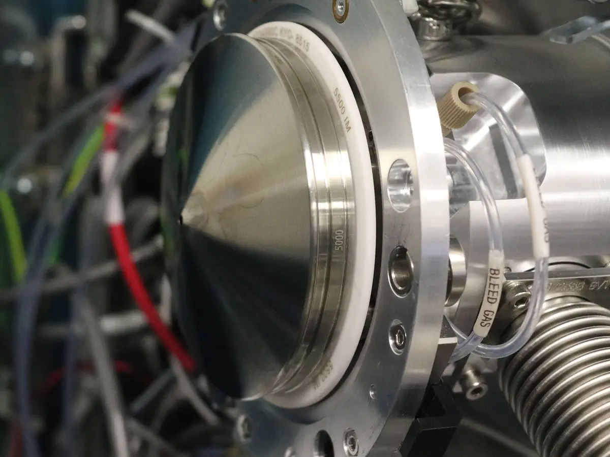 A close-up photo of a complex piece of scientific equipment, likely a vacuum chamber or particle accelerator component…