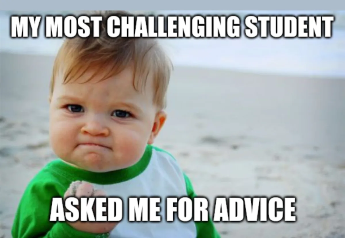 A baby with a scrunched-up, frustrated face wearing a green and white shirt stands on a sandy beach. The text overlaid on…