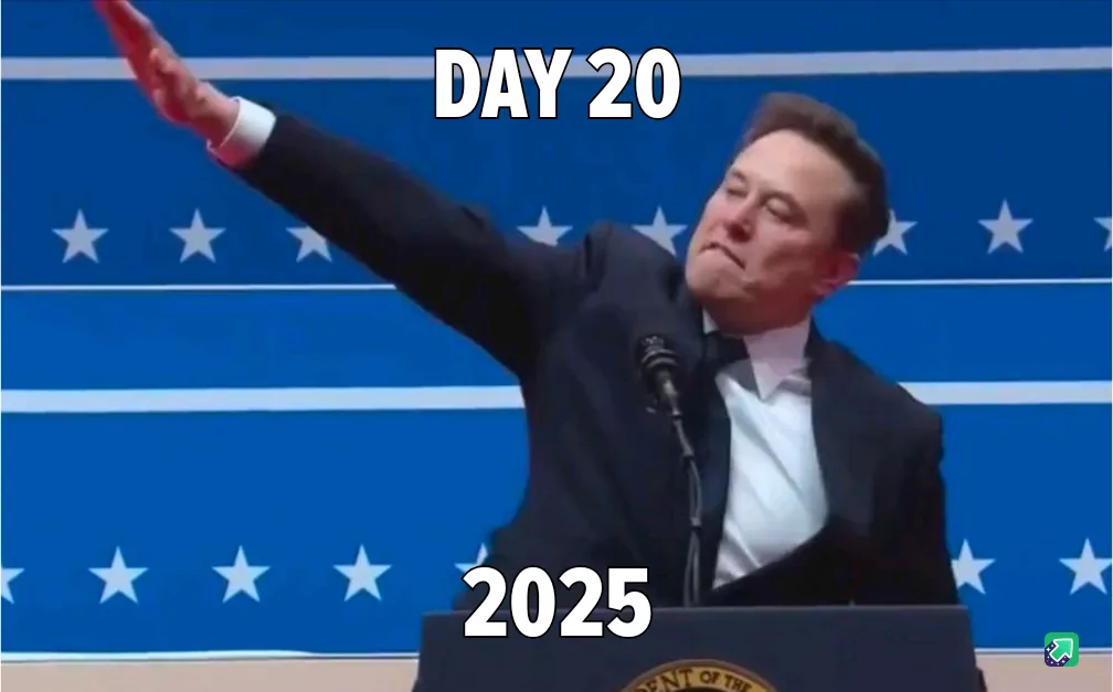 A man in a dark suit stands at a podium with a blue background featuring white stars and stripes. He has his right arm…