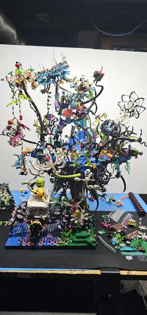 A complex, chaotic, and densely packed LEGO diorama featuring numerous minifigures, colorful pieces, and intricate…