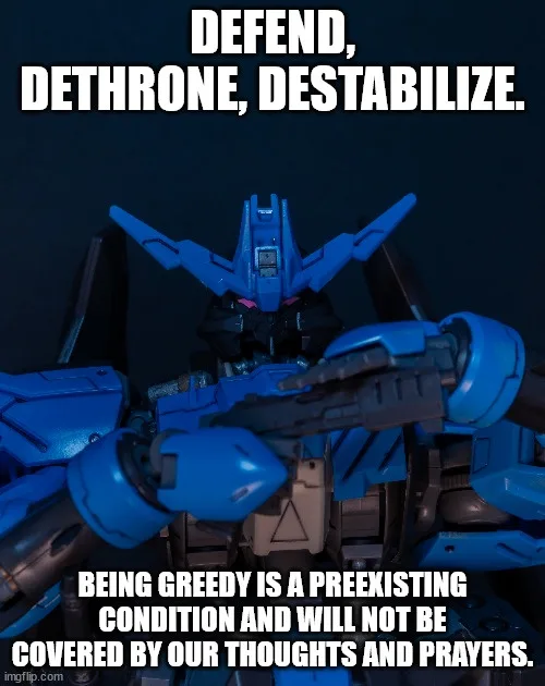 A blue and black robot model, resembling a Gundam, is shown from the chest up against a dark background. The robot holds a…