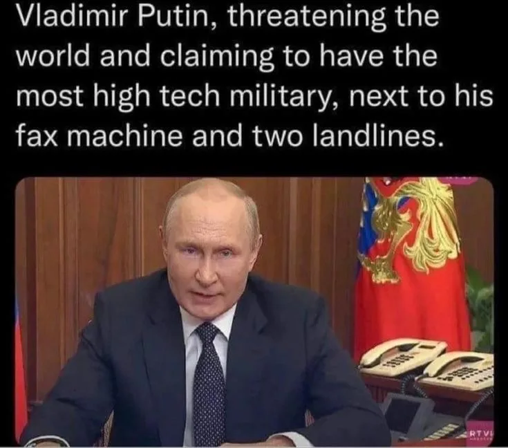 A still image of Vladimir Putin seated at a desk in a formal setting, with a Russian flag visible behind him. On the desk…