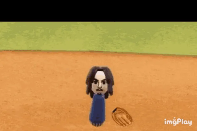 A still image from a video game shows a cartoon character with long dark hair and a blue shirt standing on a brown baseball…