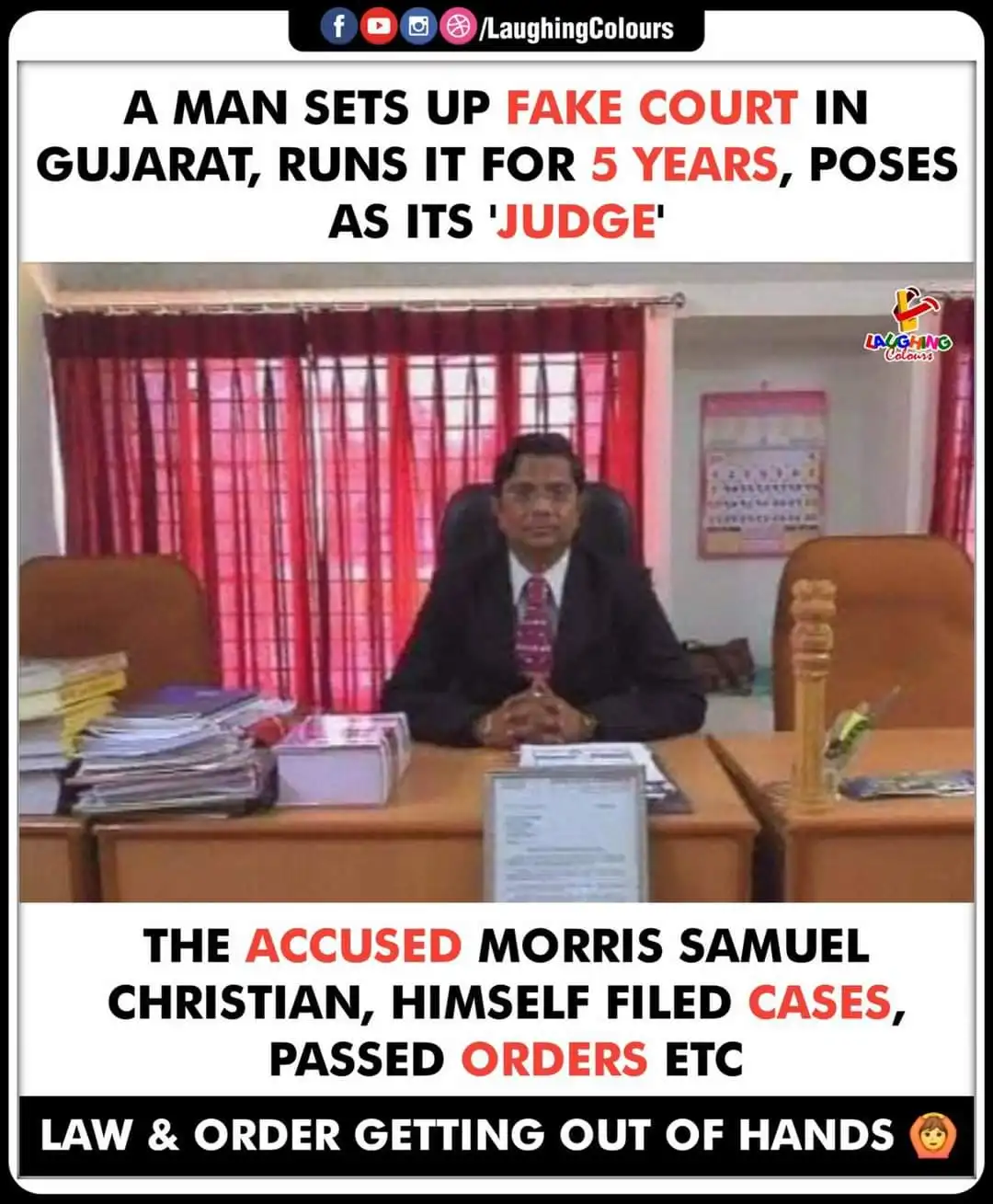 A man in a suit sits at a desk with stacks of papers and a gavel, posing as a judge in a fake courtroom in Gujarat. The…