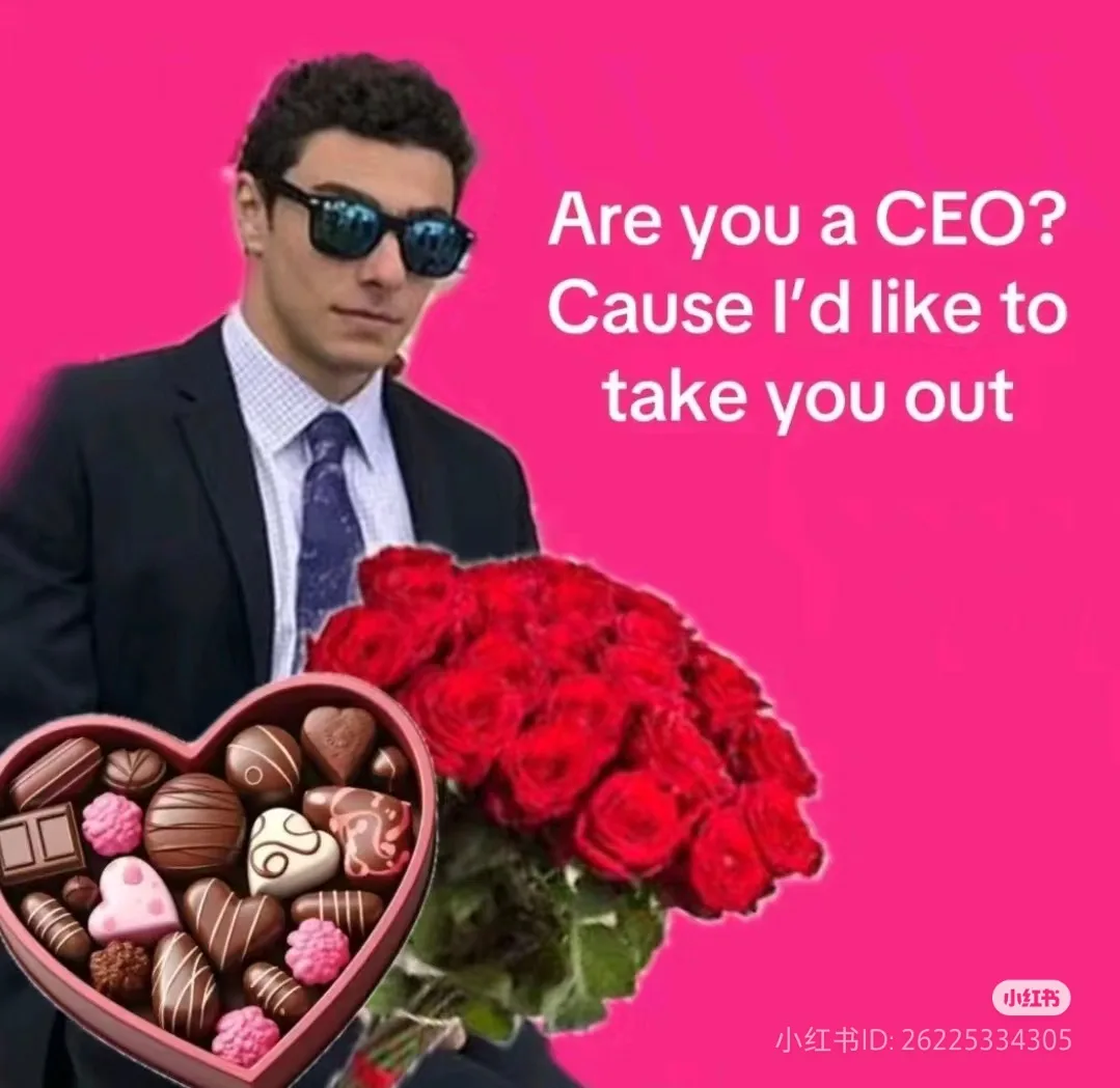 A man in a suit and sunglasses holds a heart-shaped box of chocolates and a bouquet of red roses against a bright pink…
