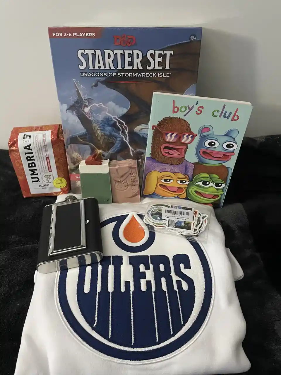 A collection of items including a D&D Starter Set, a 'boy's club' book featuring cartoon characters, an Edmonton Oilers…