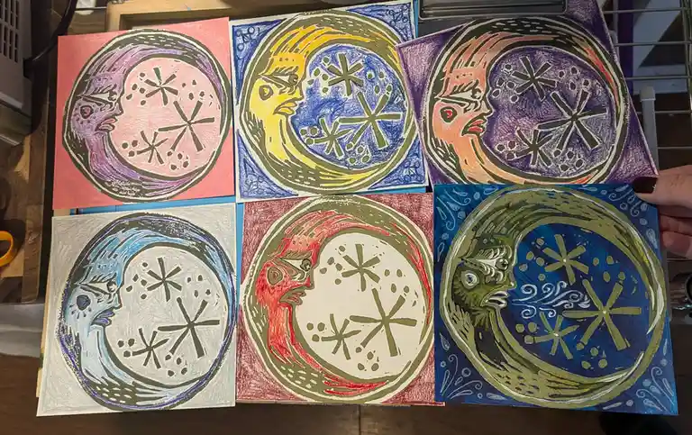 Six hand-drawn, colorful artworks are displayed, each featuring a stylized, symmetrical face within a circular frame, with…