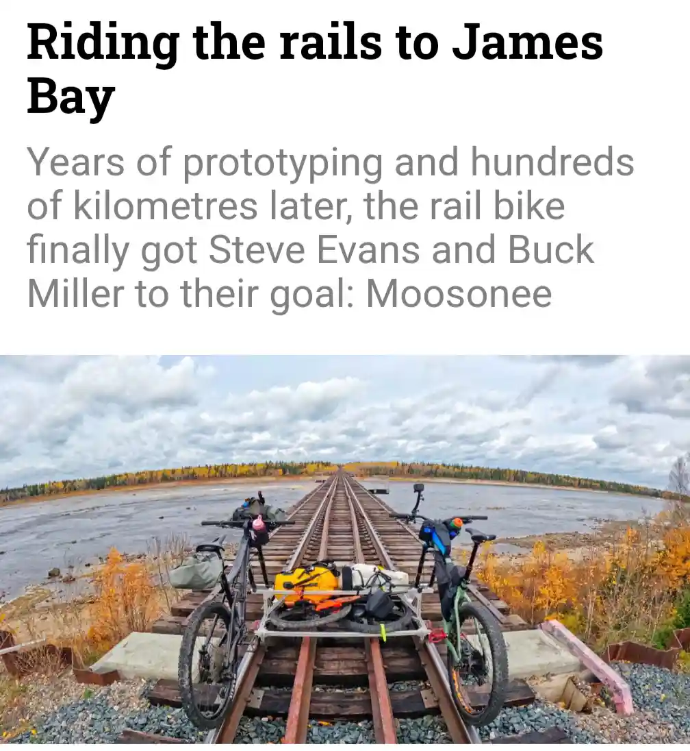 Two bicycles are positioned on railroad tracks that stretch into the distance across a wide, shallow body of water, flanked…