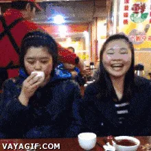 A six-panel GIF shows two women at a restaurant. The woman on the left initially eats something, then reacts with shock and…