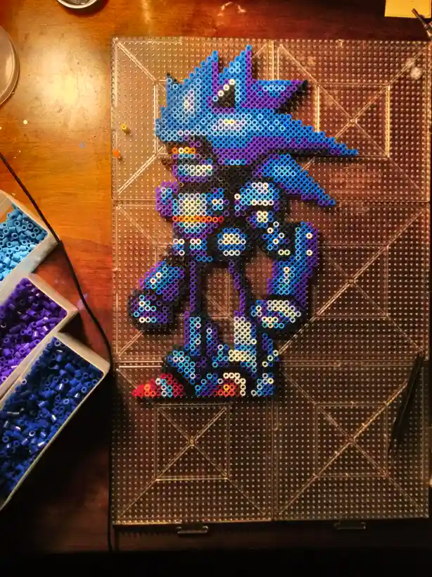 A handmade perler bead artwork of the video game character Shadow the Hedgehog, created on a transparent pegboard with blue…