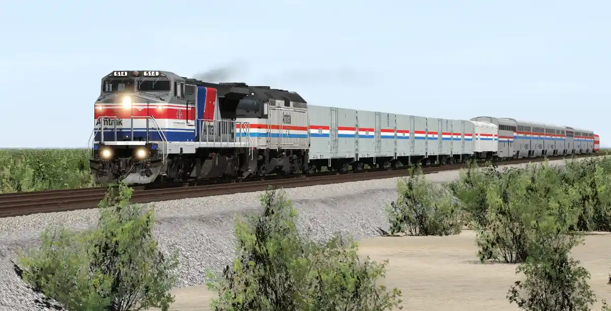 An Amtrak train with locomotive number 614 is shown traveling through a rural landscape with green bushes and gravel…