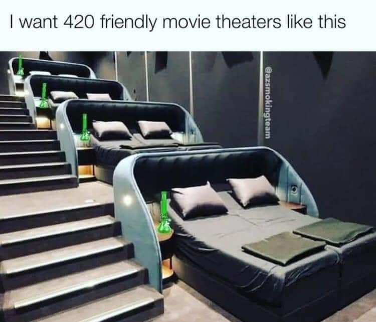 The image shows a row of luxurious, reclining bed-like theater seats arranged on ascending stairs, each with pillows and a…